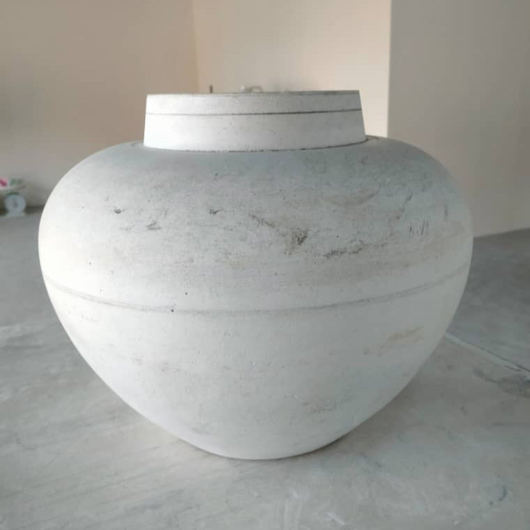 Large white urn model on a concrete floor with a neutral background