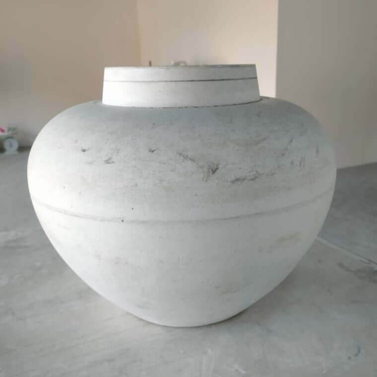Large white urn model on a concrete floor with a neutral background